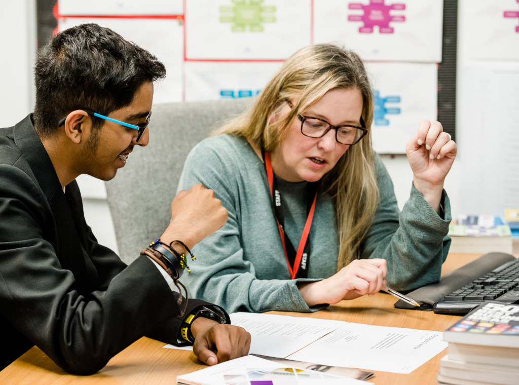 A school pupil receiving personal careers guidance from a careers adviser in a school library