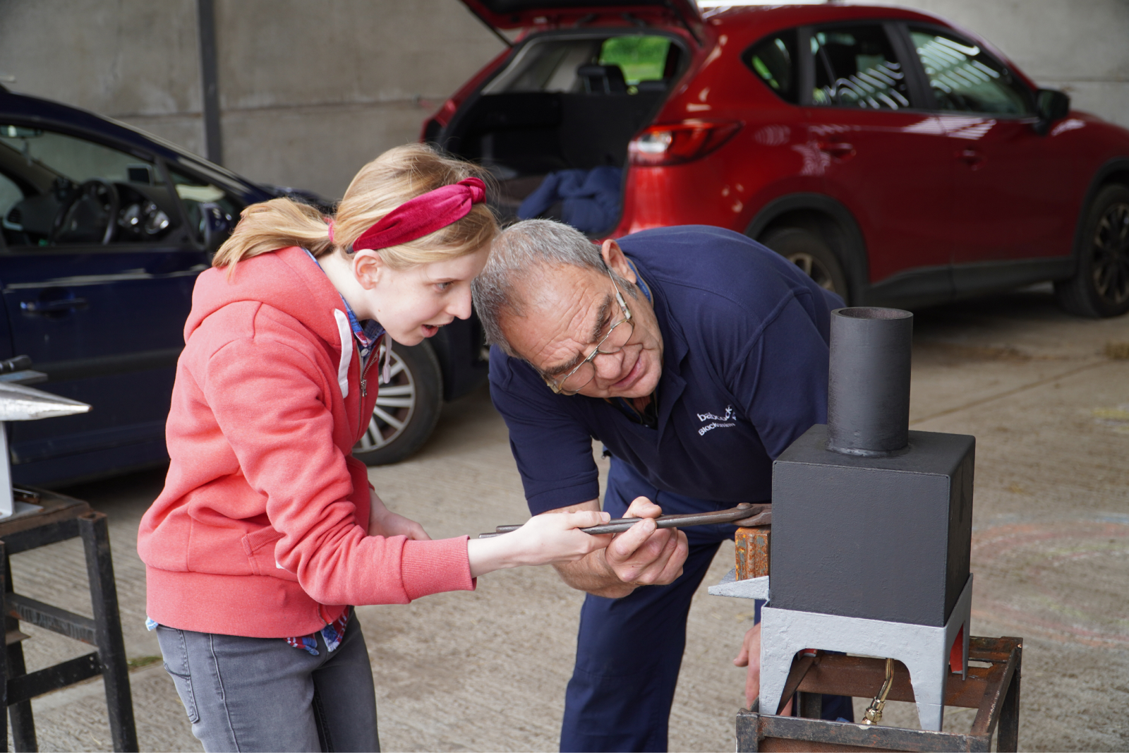 A student and an employee working with engineering tools in a workshop